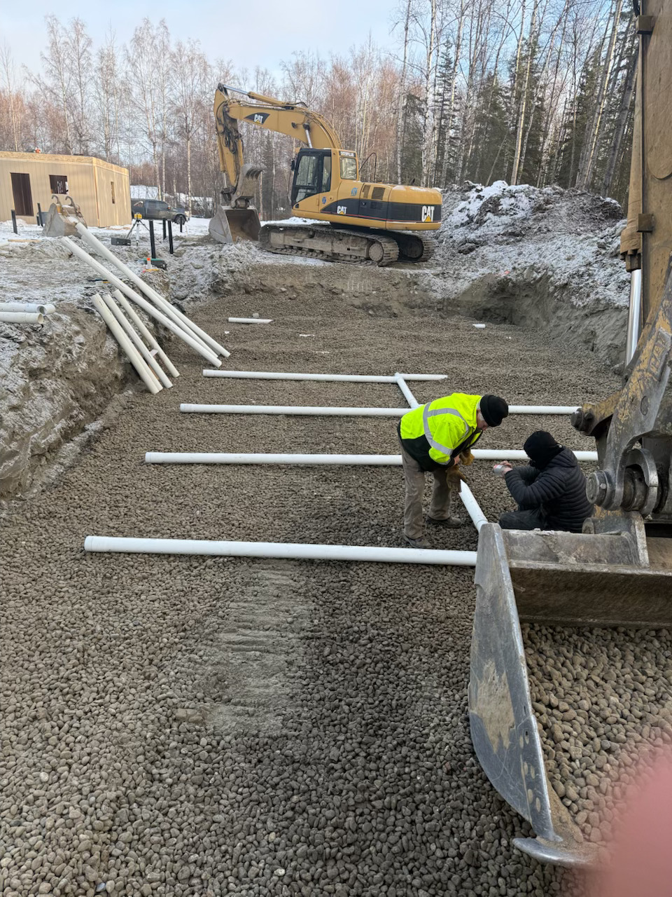 Leech field laid out in Palmer alaska with excavator in frame. 