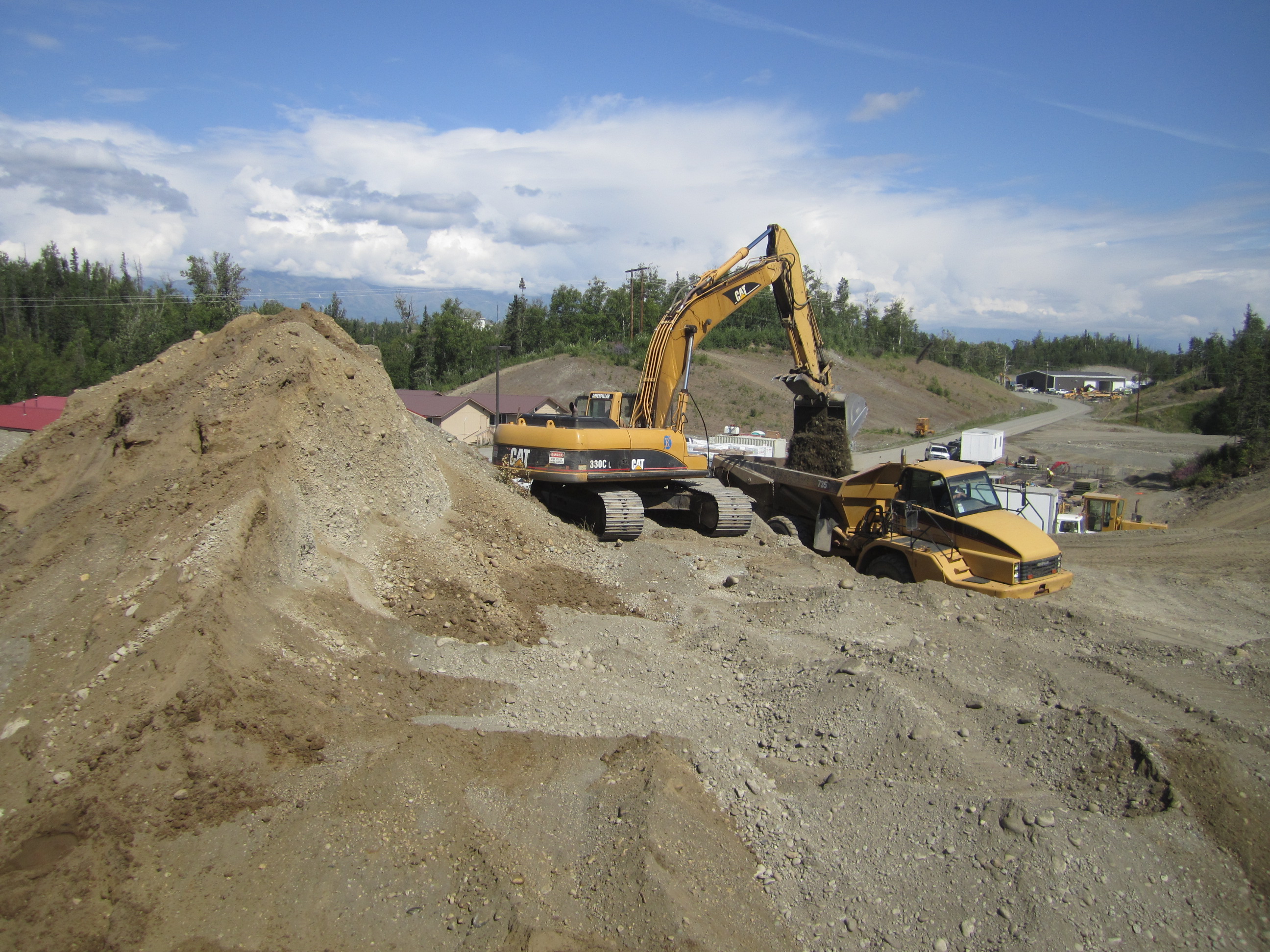 Hailing dirt with an excavator and offload truck